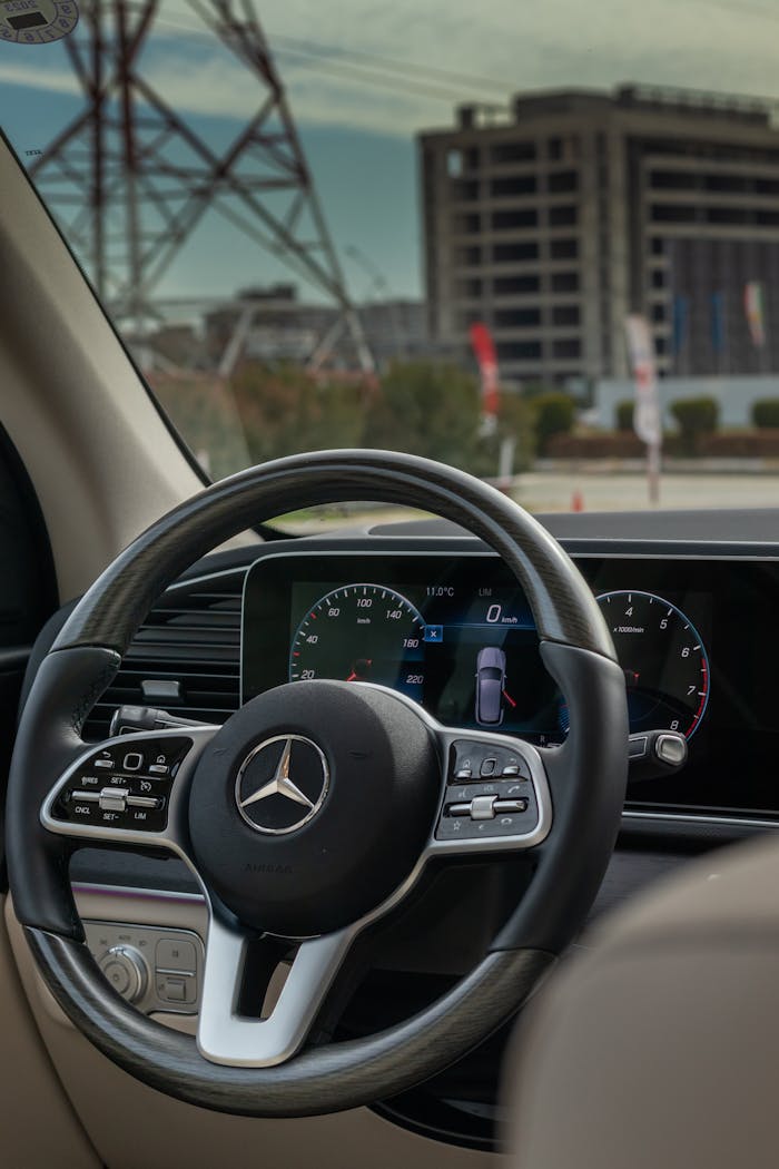 Close-up of a Mercedes steering wheel with urban scenery in Erbil, Iraq.